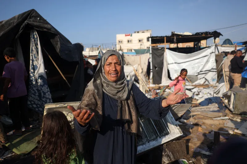 Mulher palestina se desespera enquanto acampados averiguam o estrago de ataque de Israel em campo de tendas de refugiados neste sábado (9)