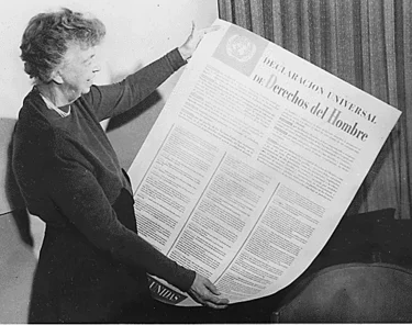 Eleanor Roosevelt segura uma versão de tamanho grande da edição do Jornal das Nações Unidas com a Declaração Universal dos Direitos Humanos em espanhol