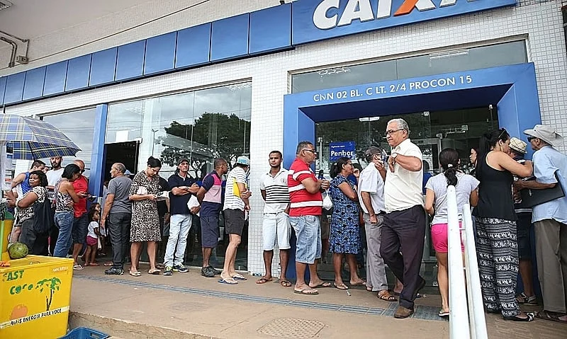 Fila de beneficiados pelo PIS em frente a uma agência da CAIXA.