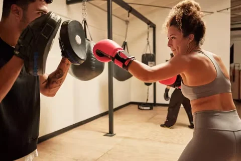 Duas pessoas fazendo treino de sparring na academia. Imagem: iStock