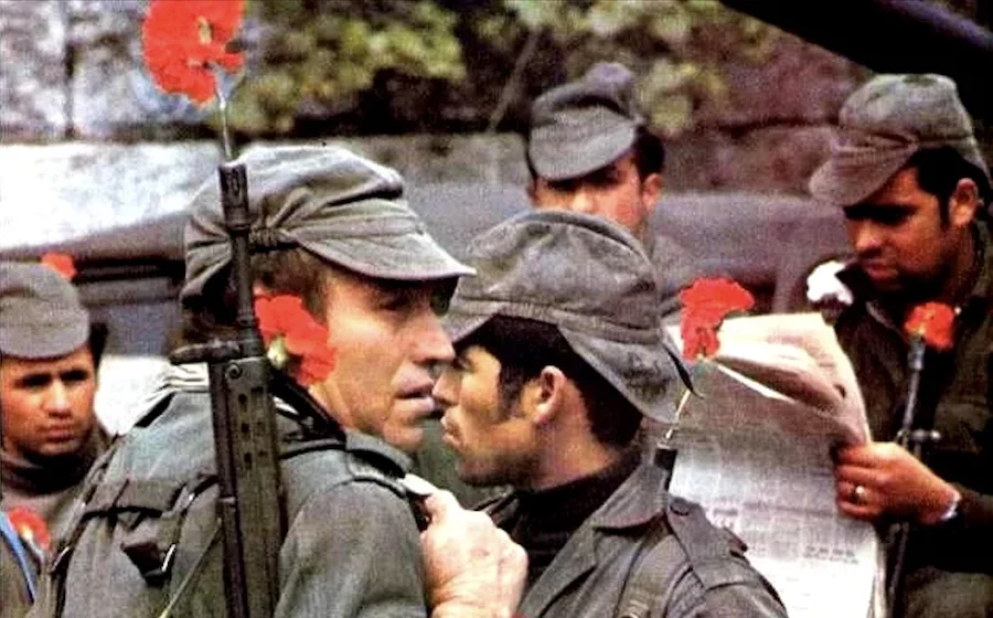 Foto dos revolucionários usando os cravos na ponta do fuzil