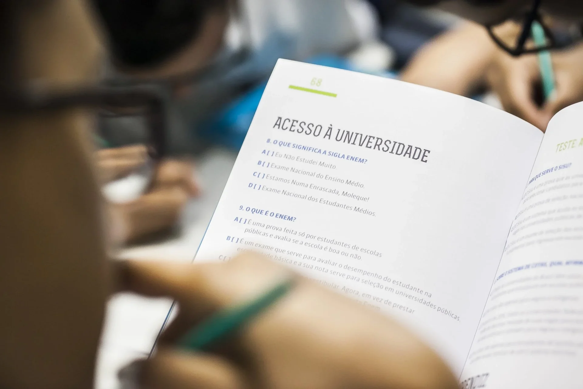 Imagem de uma pessoa lendo um livreto onde se lê Acesso à Universidade