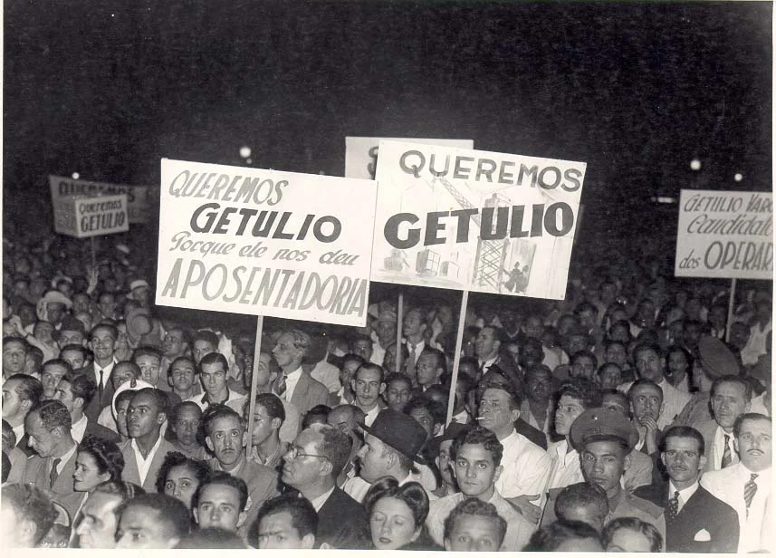 Comício Getúlio Vargas Multidão em comício demonstra apoio a Getúlio Vargas, destacando conquistas como a aposentadoria e os direitos dos trabalhadores. Imagem: Arquivo