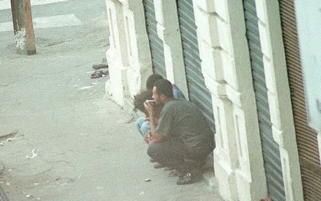 Foto de 1996 mostra pessoas fumando crack na esquina da Rua do Triunfo, um dos primeiros pontos associados à Cracolândia em São Paulo. Foto: Júlio Vilela/ Folhapress.
