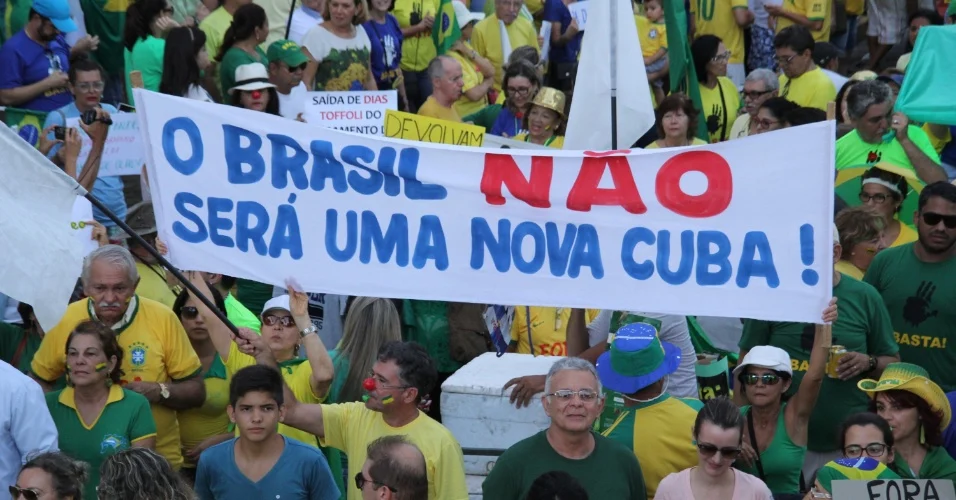 Manifestantes seguram faixa com os dizeres 'O Brasil não será uma nova Cuba' durante protesto popular em 2010. Imagem: divulgação