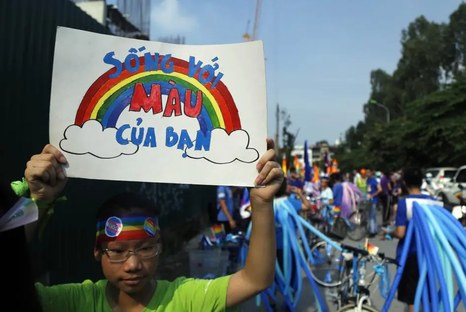 Na imagem, um jovem vietnamita segura um cartaz com os dizeres “deixe sua verdadeira cor brilhar”, durante uma marcha em defesa dos direitos da comunidade LGBTQIA+. Foto: AP Photo/Hau Dinh