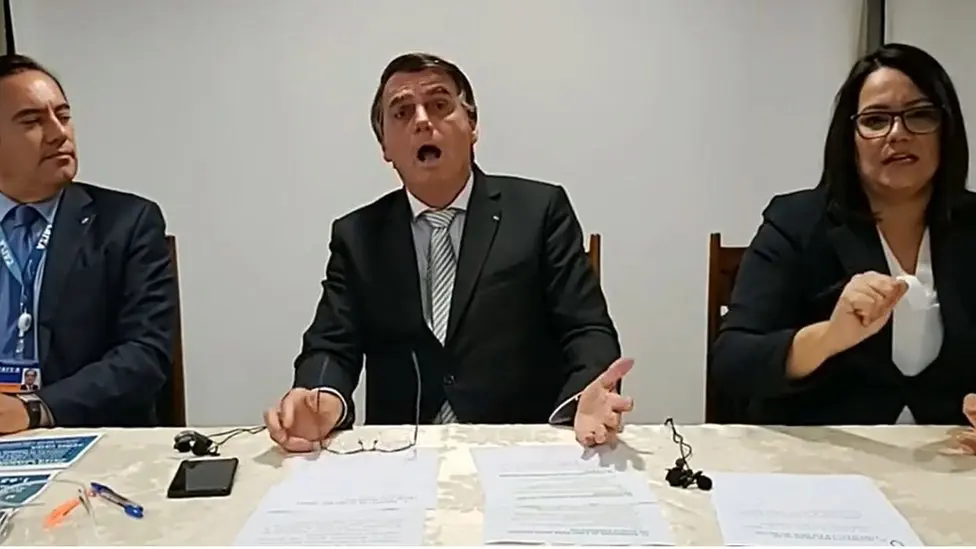 Cena exata do momento em que, durante o colapso da pandemia, com mais de 4 mil mortes por dia, o ex-presidente do Brasil imitava alguém sem conseguir respirar.  Imagem: CNN 
