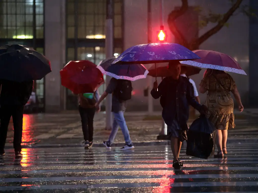 São Paulo (SP), 14/01/2026 - Pessoas usam guarda-chuva durante chuva no centro da cidade.