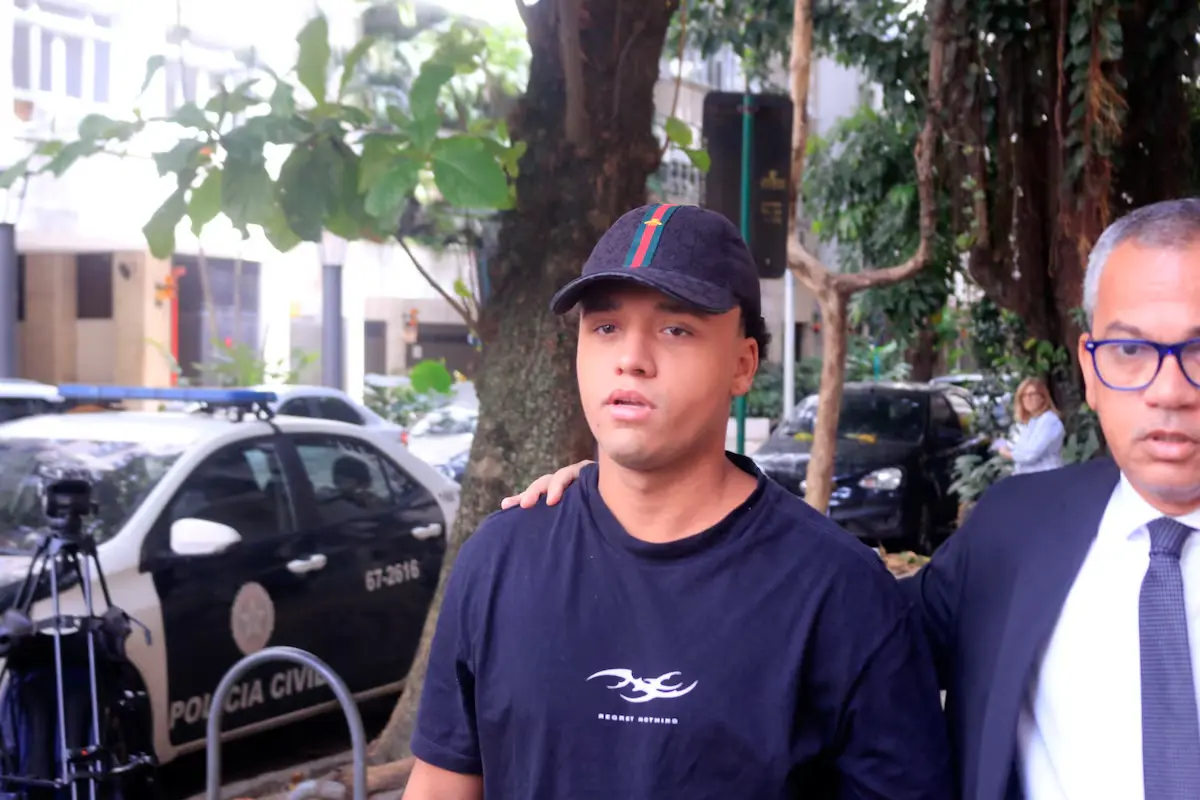 Na foto, Vitor Hugo Simonin, preso suspeito de participação no caso de um estupro coletivo em Copabacana, em 2026, usando uma camisa com a frase “Regret Nothing” (não me arrependo de nada, em tradução livre), ao se entregar à polícia. Foto: Carlos Elias Junior/Agência O Dia