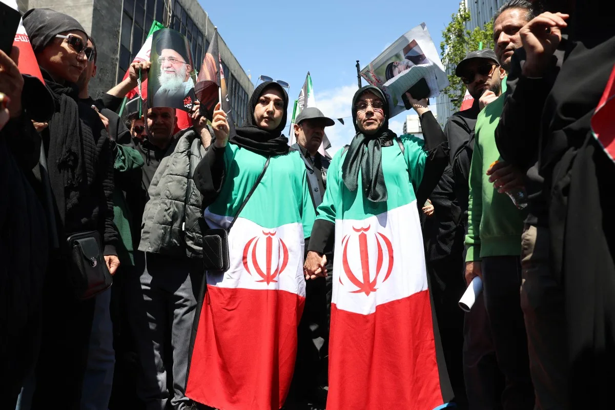 Pessoas seguram retratos do falecido líder supremo do Irã, o aiatolá Ali Khamenei, e de seu filho e sucessor, Mojtaba Khamenei, durante uma manifestação em memória de sua morte em Teerã | AFP