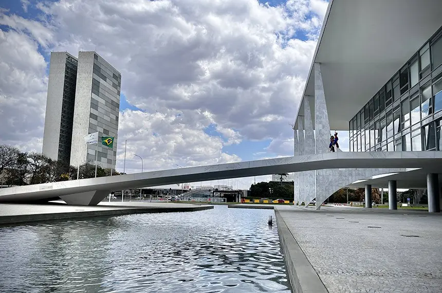 Fotografia arquitetônica da rampa do Palácio do Planalto com as torres do Congresso Nacional ao fundo sob um céu nublado. A imagem simboliza a complexa relação entre o Poder Executivo e o Legislativo, destacando como a liberação de emendas parlamentares tornou-se um instrumento central de negociação política e disputa de poder no Brasil.