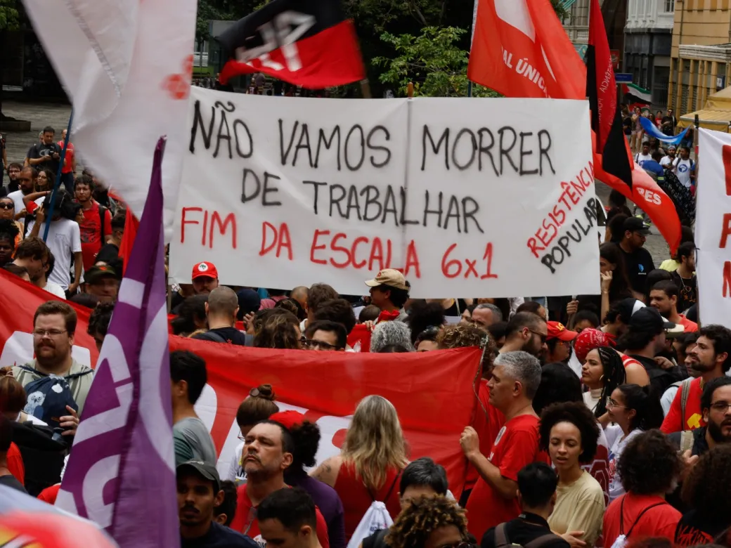 Manifestação participação social Manifestantes ocupam a Cinelândia, no Rio de Janeiro, em protesto contra a escala de trabalho 6x1. A imagem ilustra como os movimentos sociais são decisivos para conquistar direitos e redefinir o papel do Estado, provando que a democracia brasileira depende da pressão coletiva e da mobilização constante para pautar temas essenciais na agenda pública.