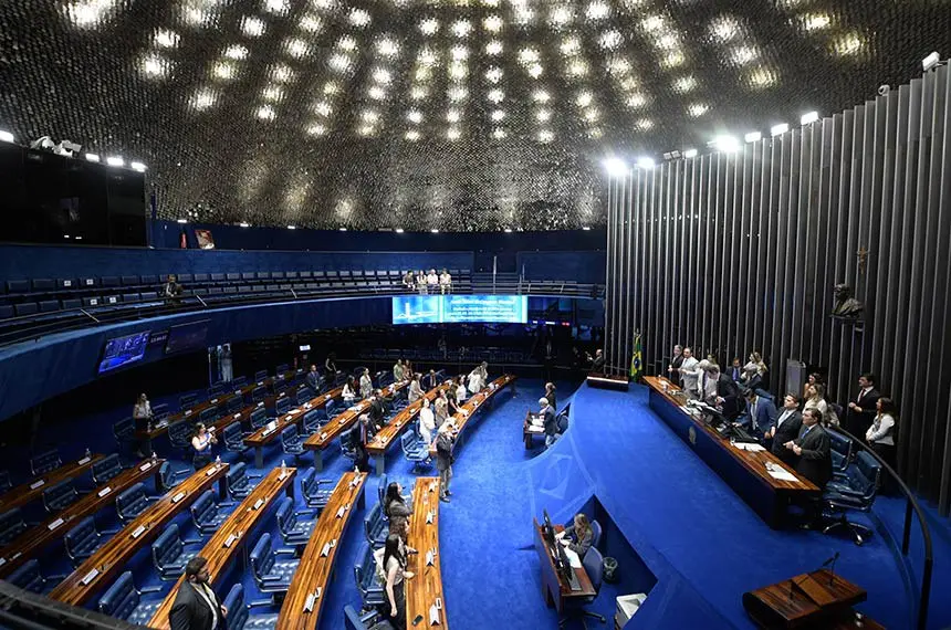 Visão panorâmica do interior do Plenário do Senado Federal, mostrando as bancadas azuis ocupadas por parlamentares sob uma cúpula iluminada. O registro visual reforça a importância das frentes institucionais e legislativas, como o Marco Civil da Internet e novos projetos de lei, na disputa pela regulação das plataformas digitais para combater a violência e garantir direitos no espaço virtual.