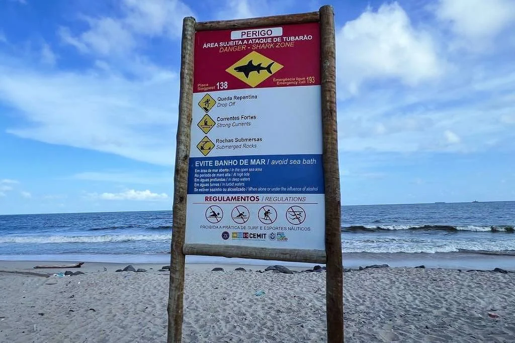 Placa em praia de Olinda indicando risco que área é sujeita a ataque de tubarão