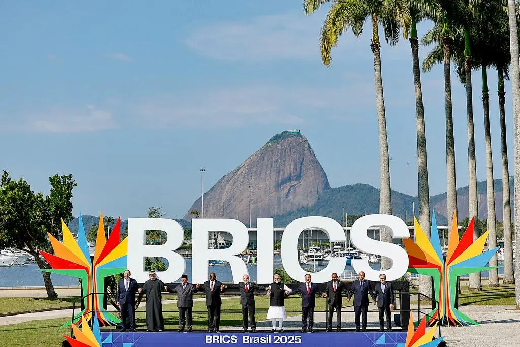 Líderes mundiais no Rio de Janeiro diante do painel "BRICS Brasil 2025". A imagem ilustra a articulação de novos centros de poder que buscam alternativas ao domínio do dólar.