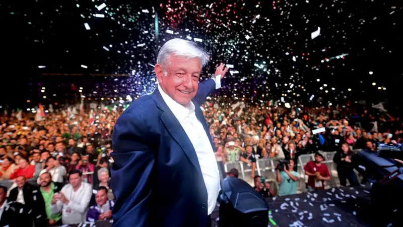 Fotografia do ex-presidente do México, López Obrador, celebrando sua eleição em 2018 sob uma chuva de confetes prateados. O registro exemplifica o populismo de esquerda, demonstrando como a mobilização emocional e a oposição a uma "máfia do poder" podem ser utilizadas para sustentar agendas de redistribuição de renda e soberania popular.