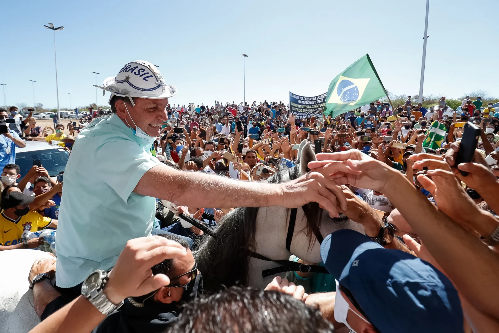Fotografia de Jair Bolsonaro montado em um cavalo, cercado por uma multidão de apoiadores no Piauí. A imagem ilustra o populismo de direita no Brasil, caracterizado pelo estilo de liderança carismática, apelo ao povo comum e o uso estratégico de símbolos nacionais e regionais para mobilizar afetos políticos e enfrentar o sistema tradicional.
