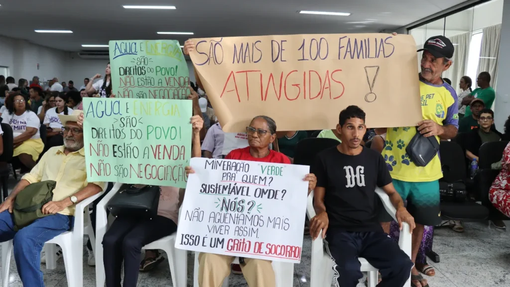 Faixas exigem direitos: comunidades isoladas pela mineração de lítio ocupam a audiência pública exigindo direitos | Crédito: Kátia Torres