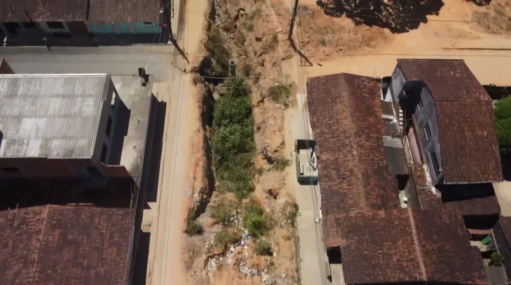Cratera aberta há quatro anos no bairro Vila Rica, em Rio Largo (AL), evidencia o abandono de uma obra de saneamento que nunca foi concluída. Apesar dos milhões em emendas parlamentares destinados ao município, moradores seguem convivendo com a falta de infraestrutura básica. Foto: reprodução/Orçamento Secreto.