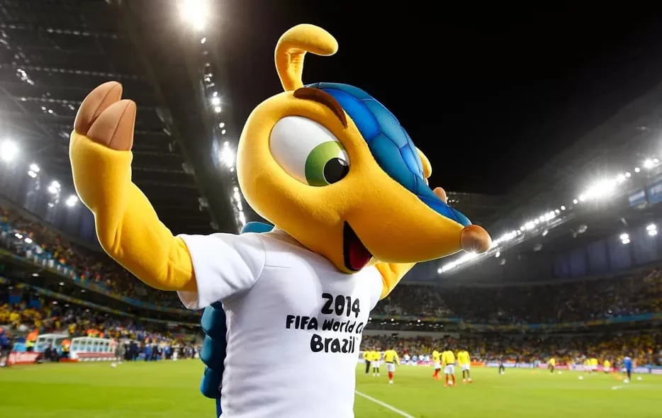 Fuleco, mascote da Copa do Mundo Brasil 2014, tatu-bola amarelo com casco azul, acenando no estádio durante o torneio
