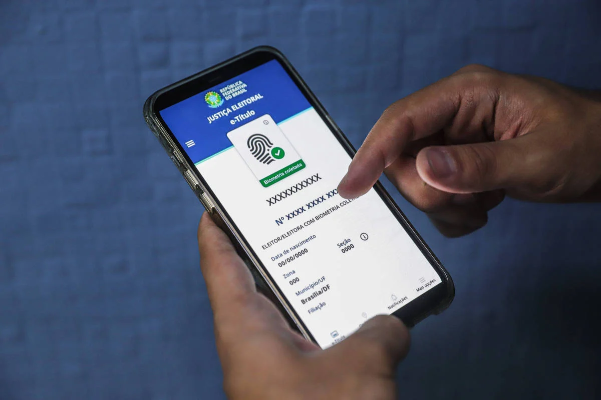 Eleitor exibe o aplicativo e-Título em smartphone; o pedido de voto em trânsito deve ser feito no site do TSE, pelo Autoatendimento Eleitoral, ou em cartórios eleitorais - Rafaela Araújo - 16.set.24/Folhapress