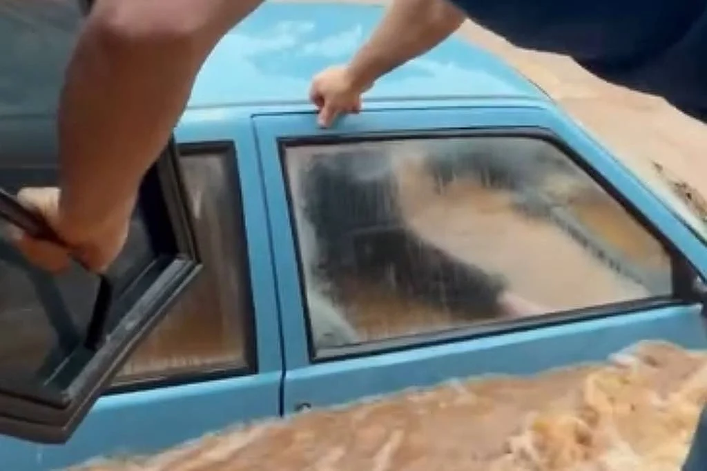 Em Ciríano (RS), um idoso dentro de um carro quase submerso foi resgatado pela janela por um homem que se equilibrava apoiado em uma retroescavadeira, nesta terça-feira (21); o idoso foi salvo e está bem - Jonathan Robson Passari