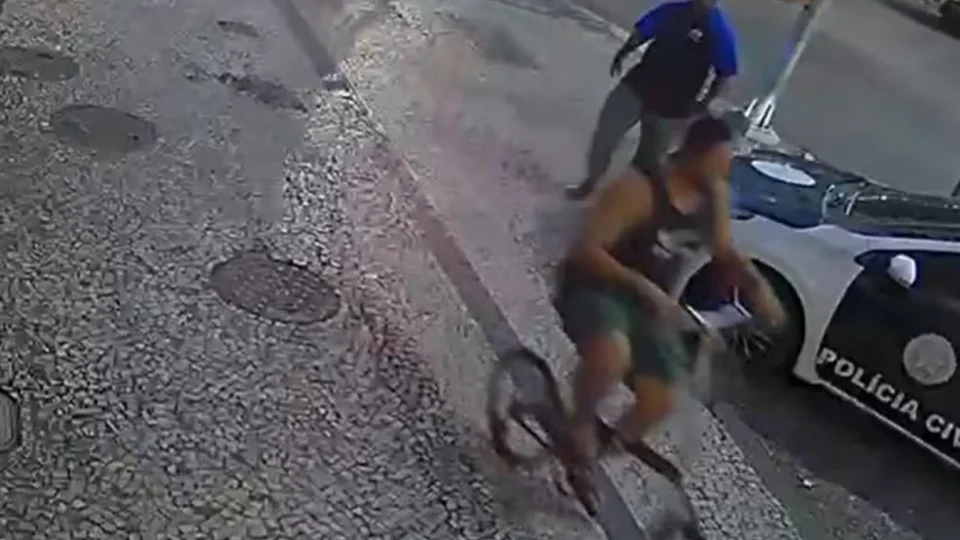 Segurança preso por espancamento chega à delegacia com bicicleta da vítima
