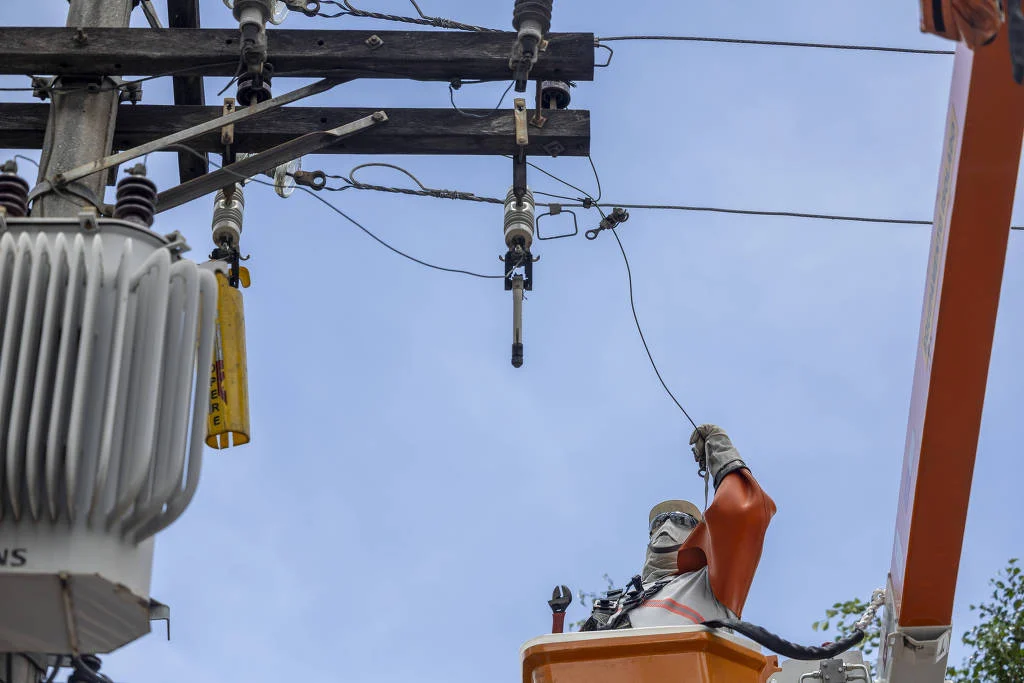 Um técnico de concessionária trabalhando em rede elétrica de um prédio no bairro da Mooca, zona leste de São Paulo - Danilo Verpa - 15.dez.2025/Folhapress