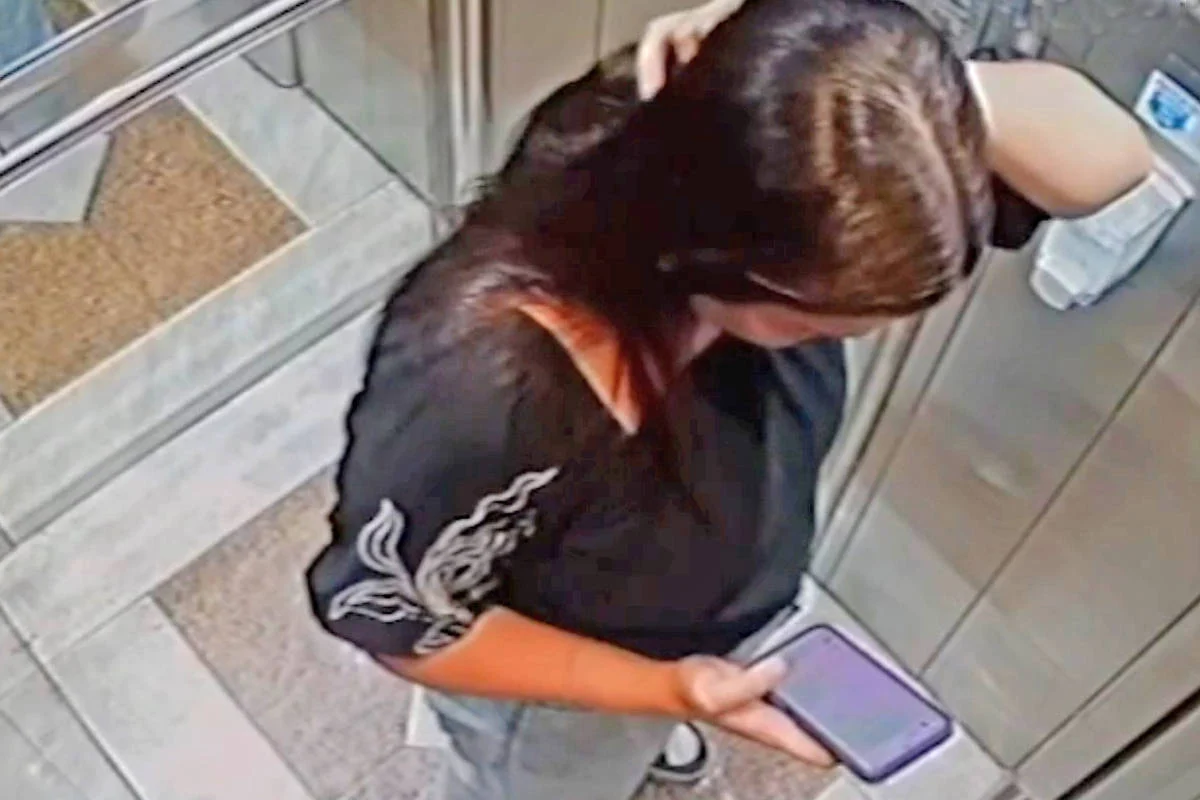 Isabelle Caracristi, 22, mexe no celular em um elevador horas antes de morrer - Reprodução/TV 
