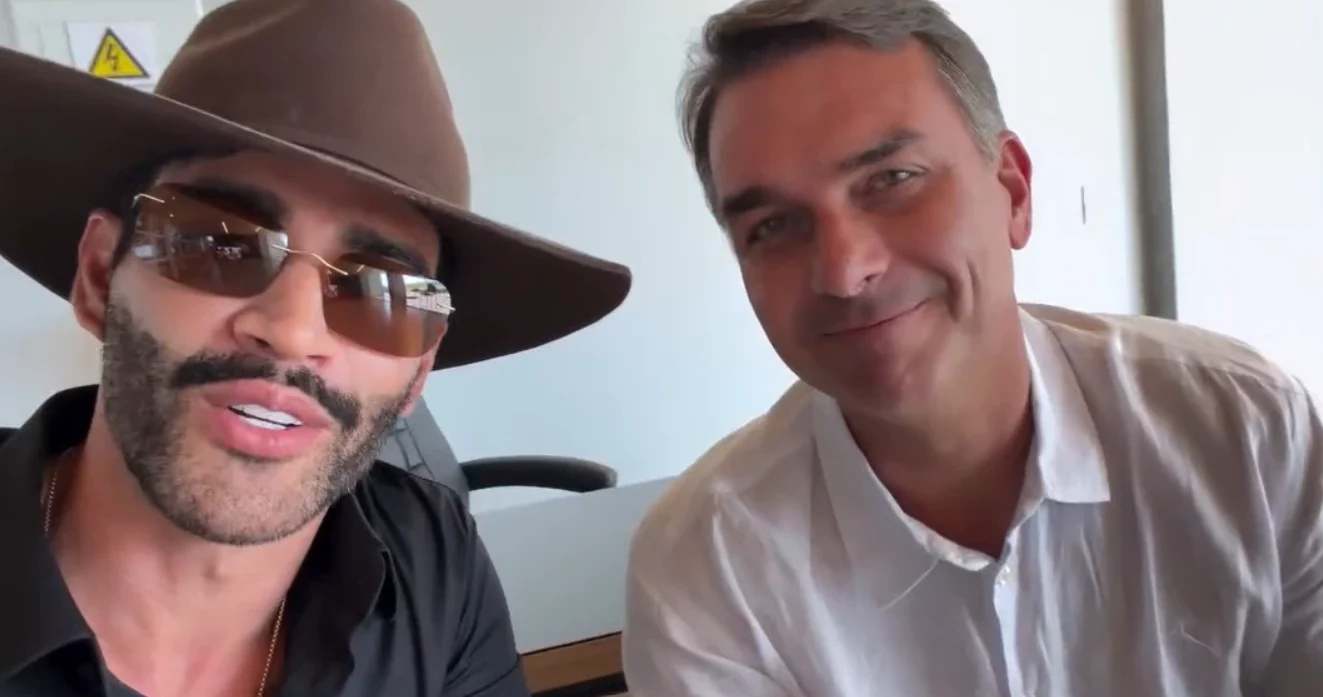 Gusttavo Lima e Flávio Bolsonaro posam para foto com jatinho ao fundo. Foto: Reprodução / redes sociais