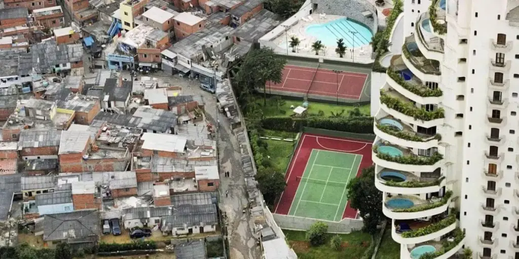 Prédio no Morumbi com piscinas na varanda contrasta com a favela de Paraisópolis, em São Paulo. Imagem povoou livros didáticos na década de 1990 como símbolo da desigualdade. Crédito: Ucondo