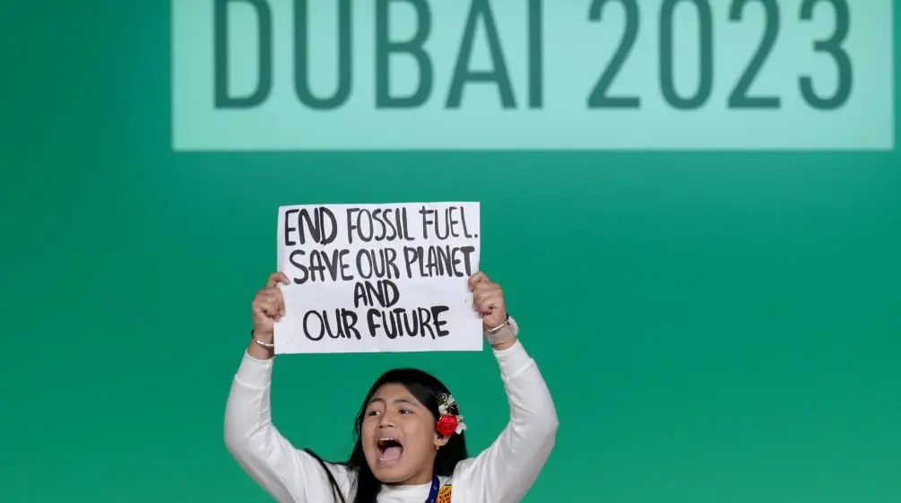 Imagem: Protesto durante a COP 28: “End fossil fuel. Save our planet and our future - Acabar com os combustíveis fósseis. Salve nosso planeta e nosso futuro” (Foto: © COP28 / Anthony Fleyhan)