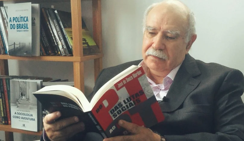 O Sociólogo José de Souza Martins posa segurando seu livro. Imagem: Editora Contexto 