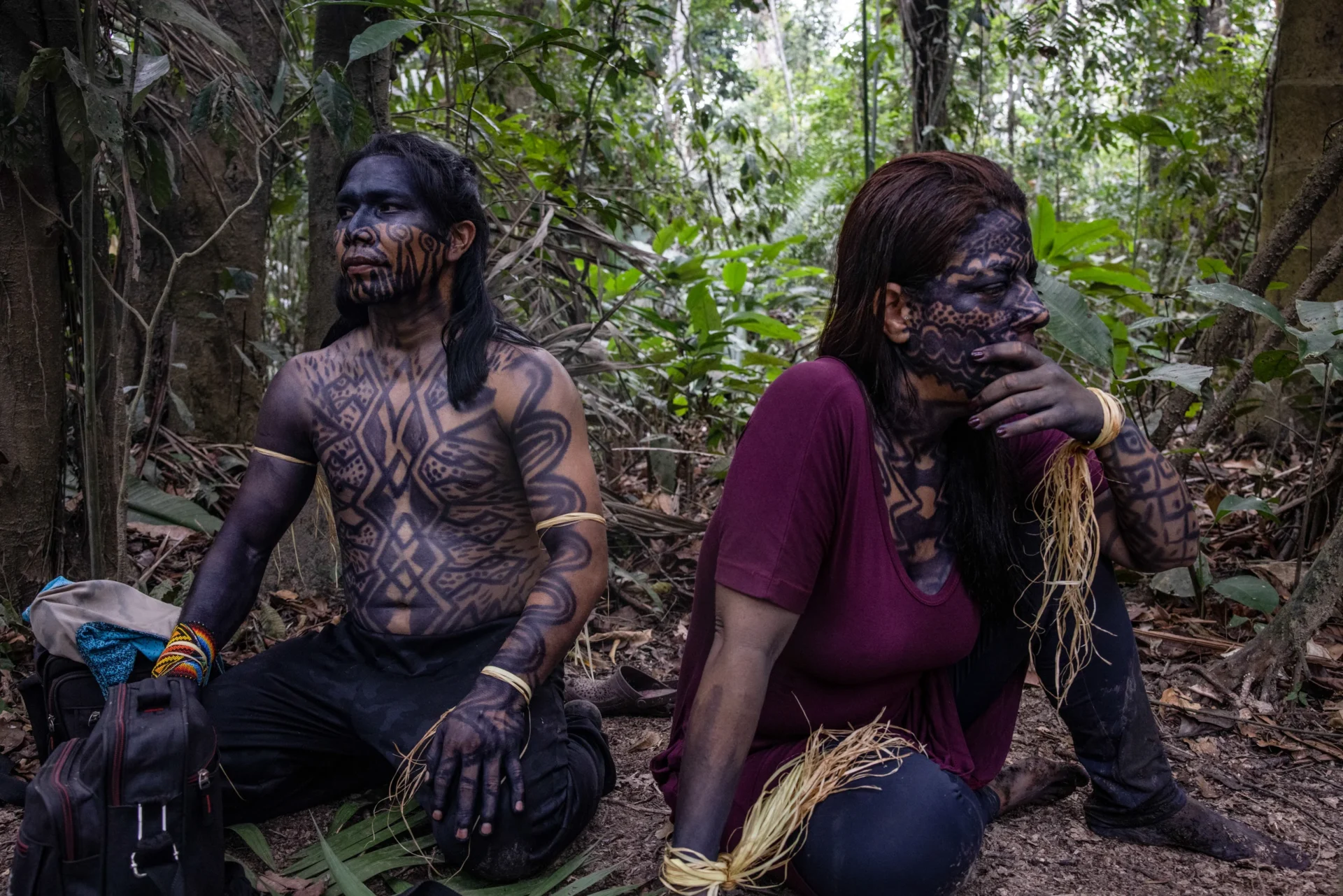 Xinã (à esquerda) e Érica cobertos de formas geométricas, feitas com tinta de nane. Segundo a tradição local, isso permite que eles sejam reconhecidos pelas cobras sagradas. O ritual de iniciação de Xinã como pajé inclui o consumo ayahuasca e rapé, além de banhos de ervas e rezas (Imagem: Victor Moriyama / Dialogue Earth)