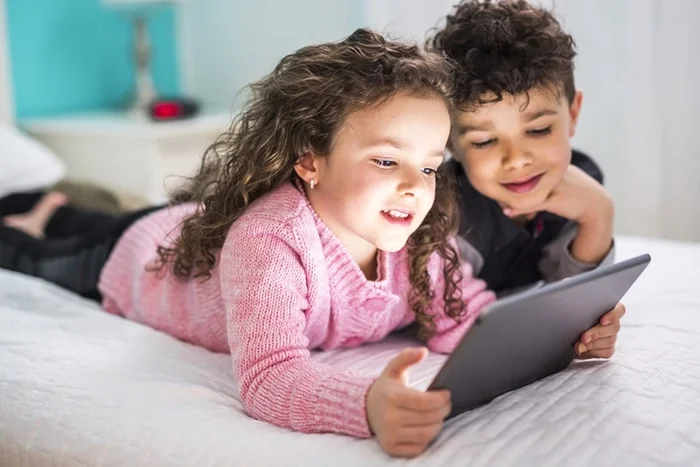 Crianças usando tablet para se divertir. Imagem: Metrópoles. 